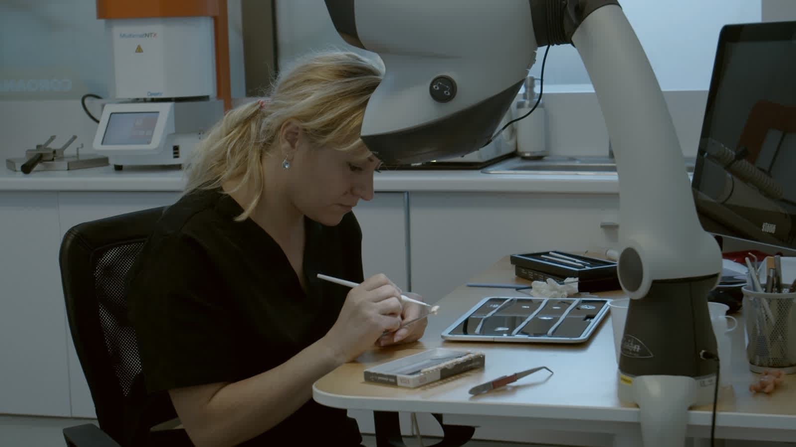 Tehnician selectând culoarea lucrării la bancul de lucru